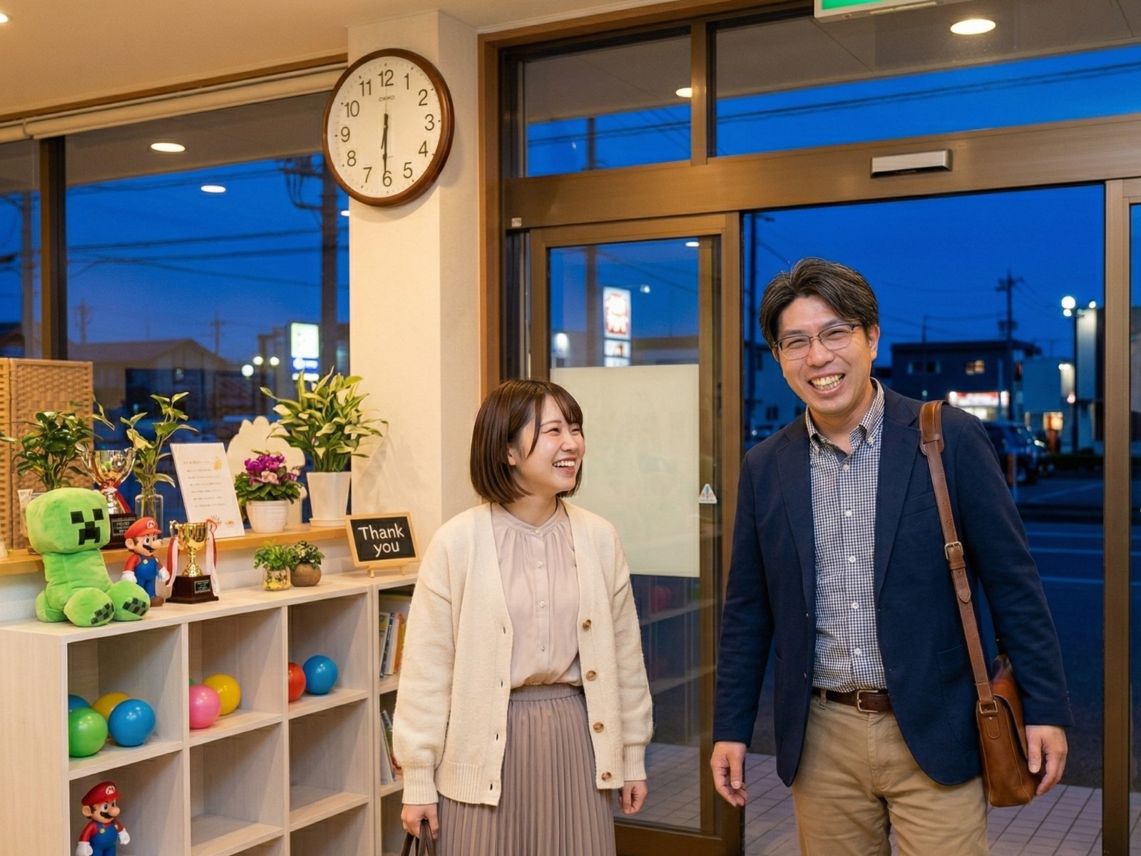 18時30分を背景に私服へ着替え、笑顔で退勤するスタッフ